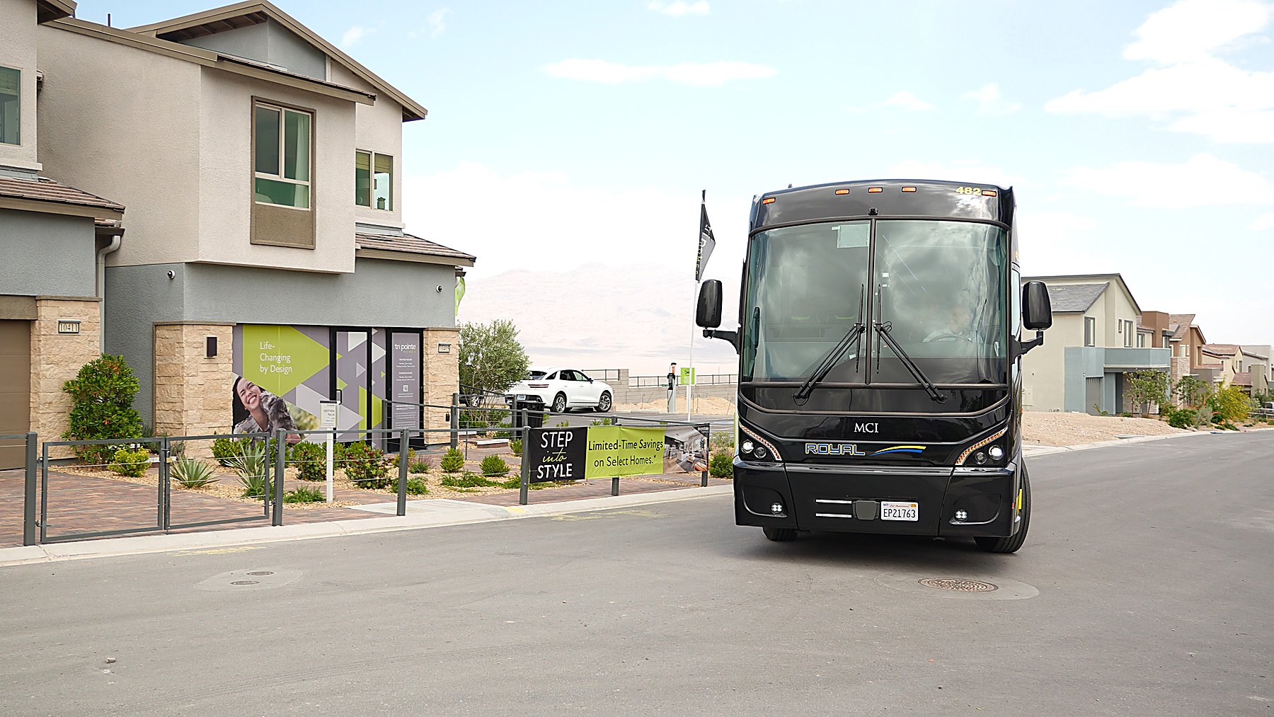 Train + Tour luxury motorcoach parked at a new home community